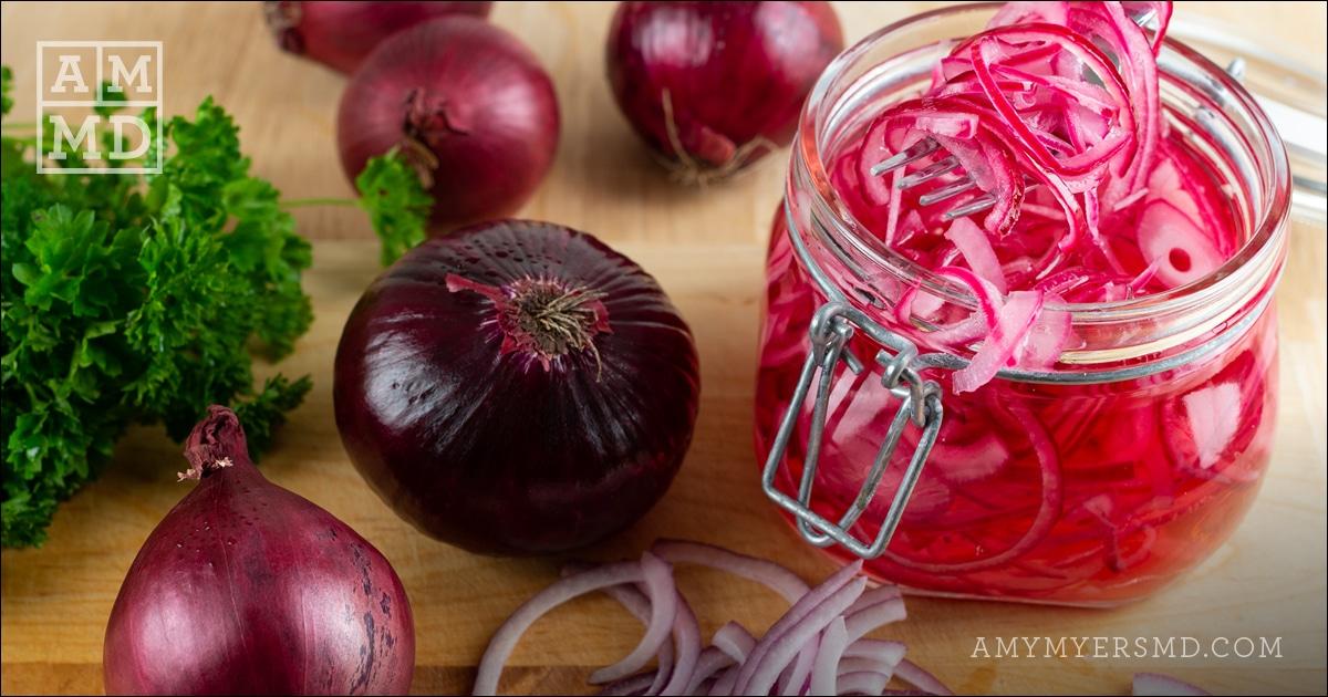 A glass jar filled with quick pickled onions made for those dealing with candida or SIBO