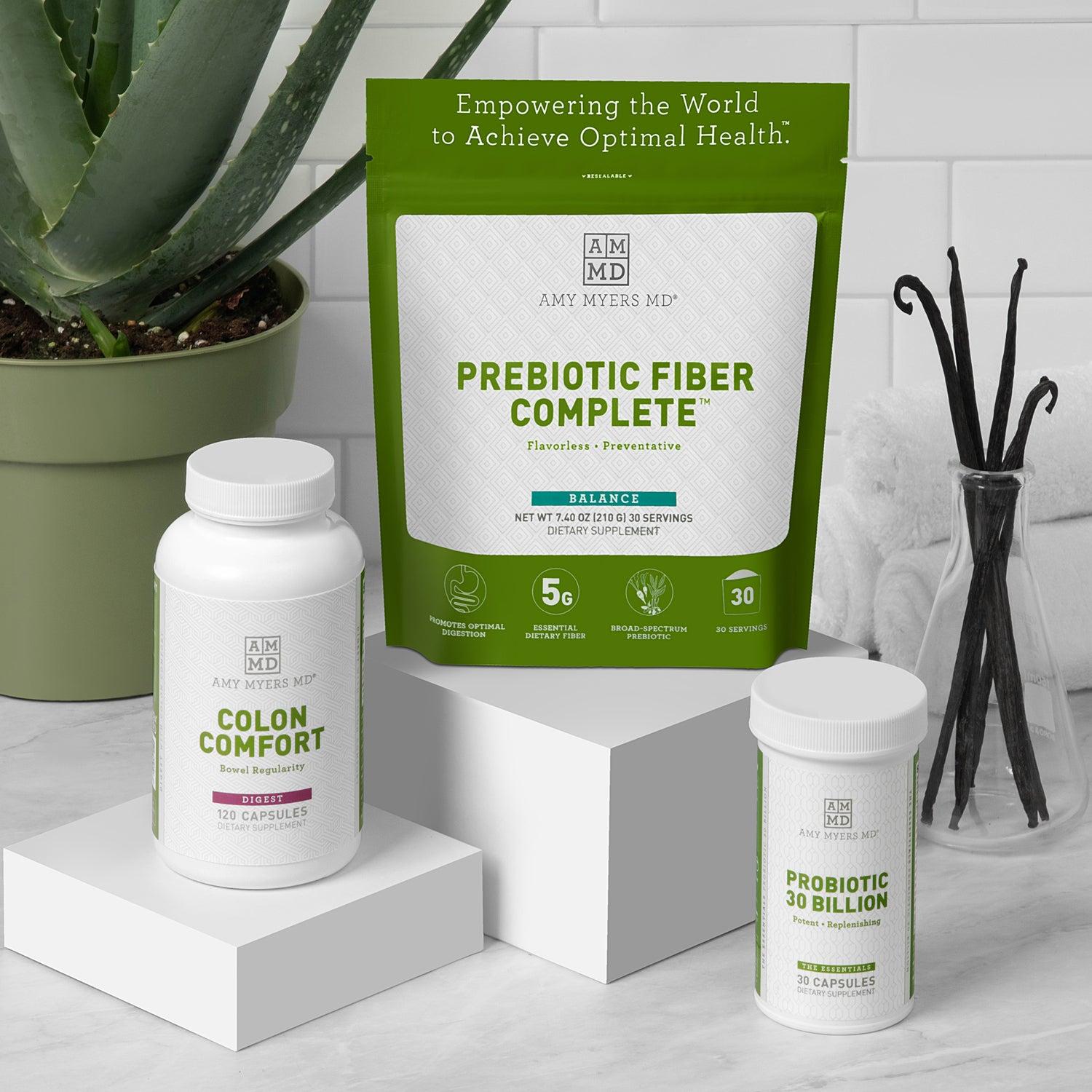 Picture of the AMMD Constipation Support kit, including Colon Comfort 120 Capsule bottle, Probiotic 30 Billion 30 Capsule bottle and Prebiotic Fiber Complete powder resealable bag.  Displayed in bathroom setting with white marble counter, with towels, and an aloe house plant in the background.
