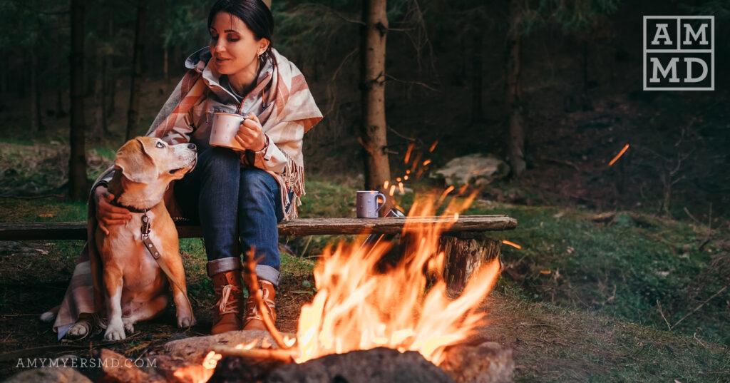 woman and dog by a campfire