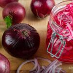 A glass jar filled with quick pickled onions made for those dealing with candida or SIBO