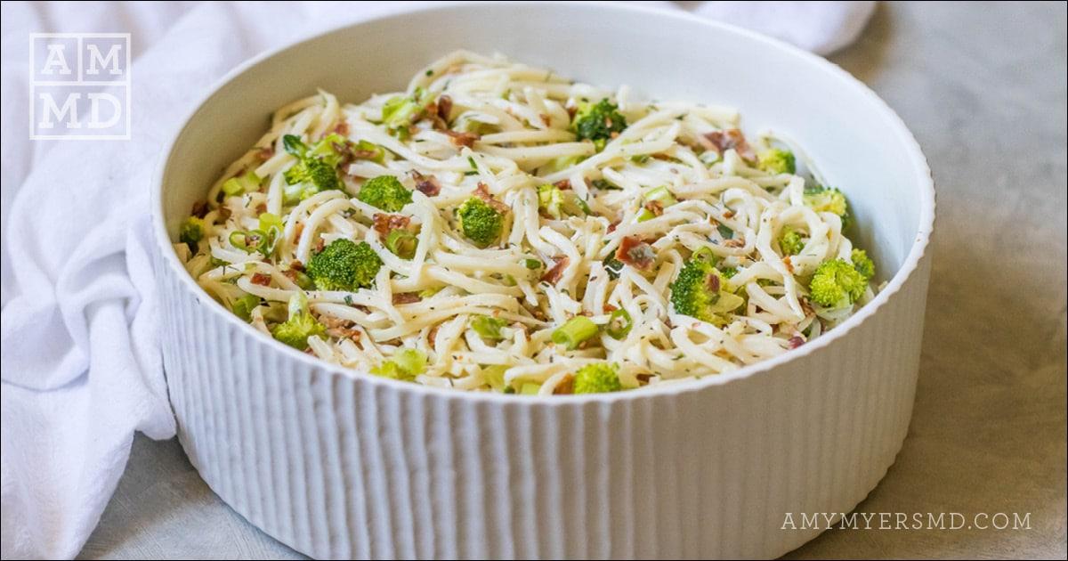 A bowl of keto-friendly, AIP bacon ranch pasta salad topped with pieces of broccoli