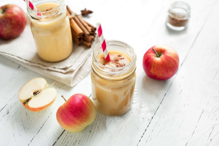 Apple pie smoothies in a mason jar and fresh apples on a table