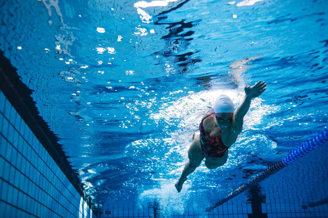 Woman swimming a lap in a pool.