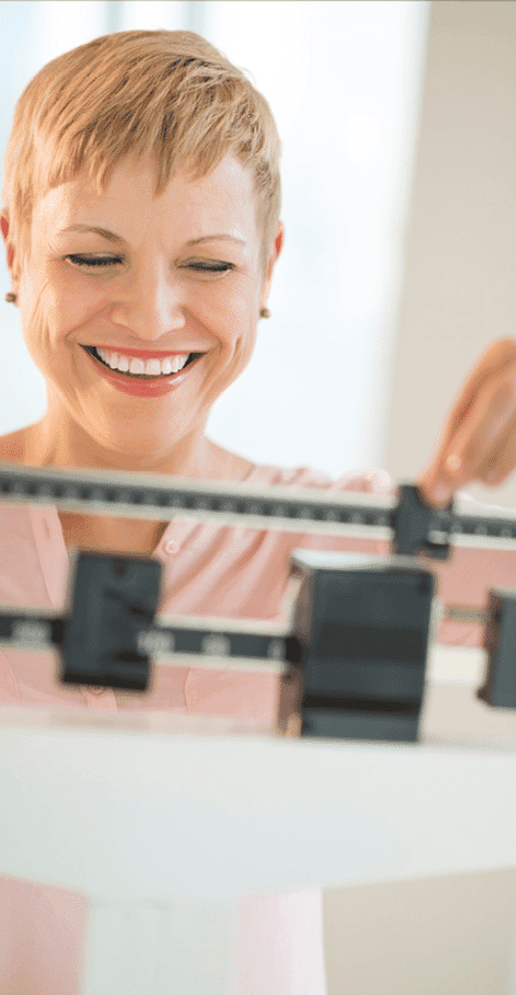 Woman smiling weighing herself