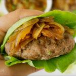 AIP-friendly turkey burger with caramelized onions wrapped in fresh lettuce leaves