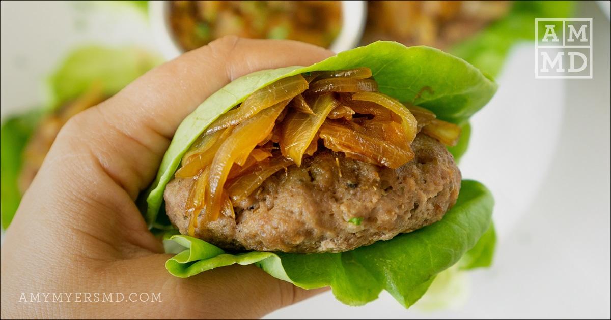 AIP-friendly turkey burger with caramelized onions wrapped in fresh lettuce leaves