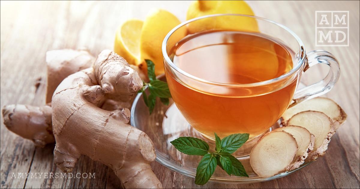 Cup of tea surrounded by ginger root and mint
