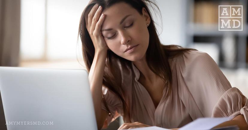 Fatigued woman in front of laptop - What's Causing My SIBO Relapse - Amy Myers MD®