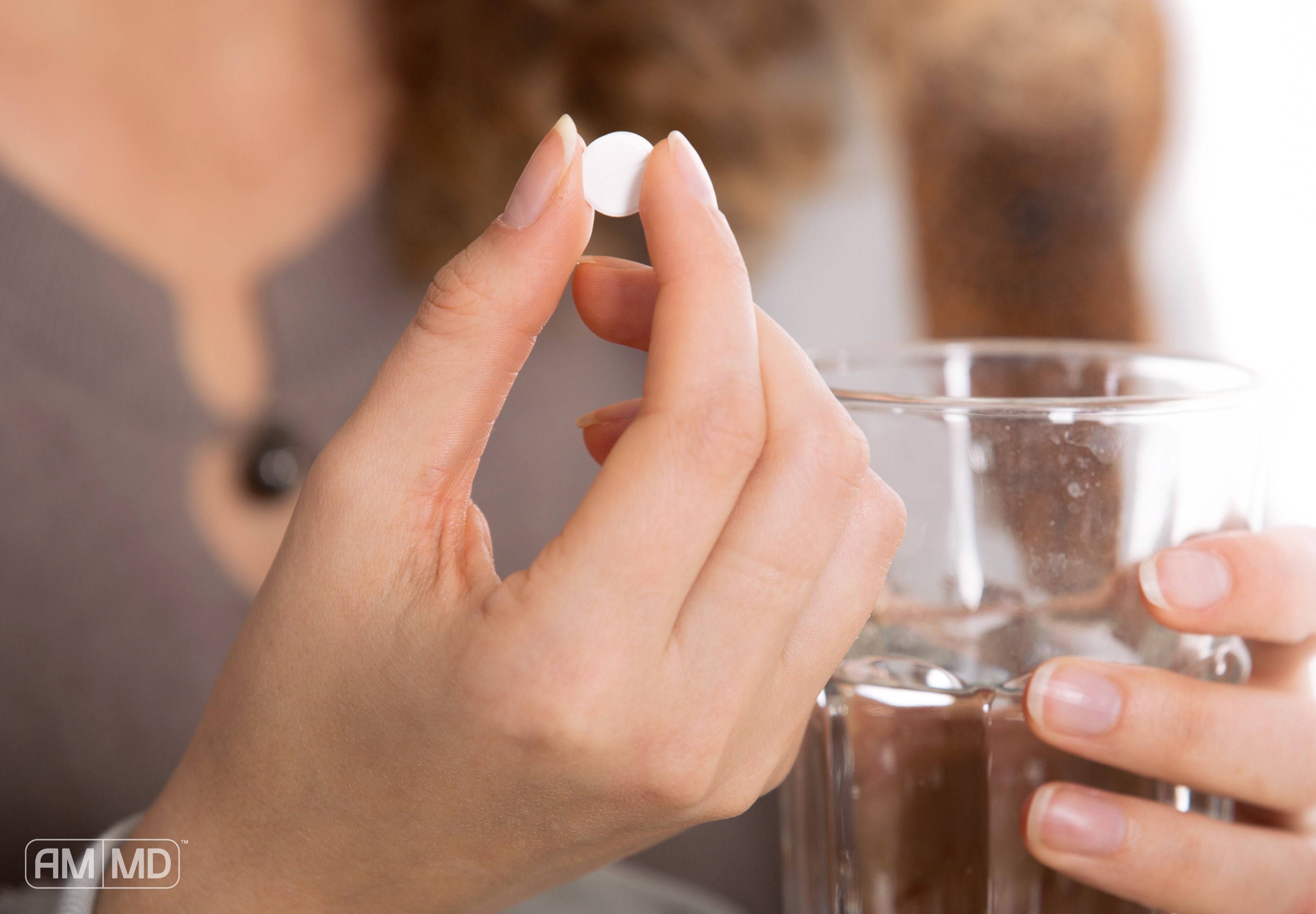 Woman holding pill and water cup - Low-Dose Naltrexone for Autoimmunity - Amy Myers MD®