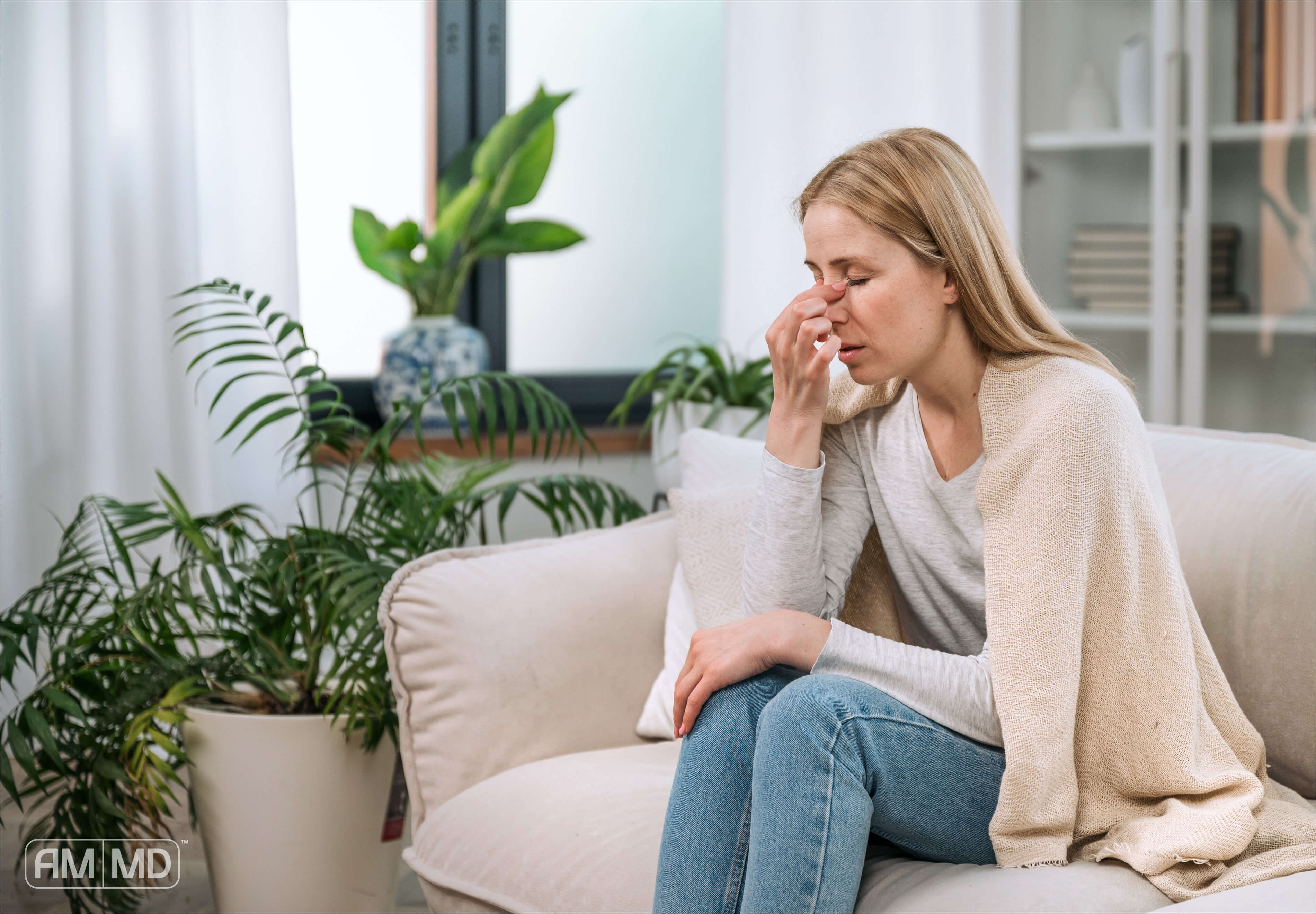 Woman on Couch holding her nose - AMMD