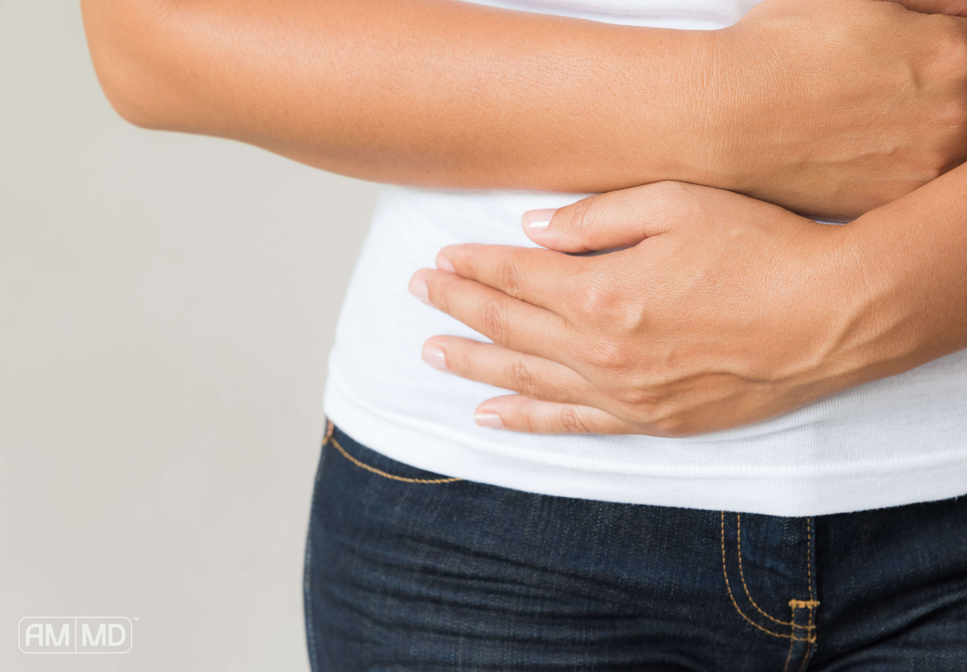 Person holding stomach - SIBO Bloating & How to Overcome It - Amy Myers MD®