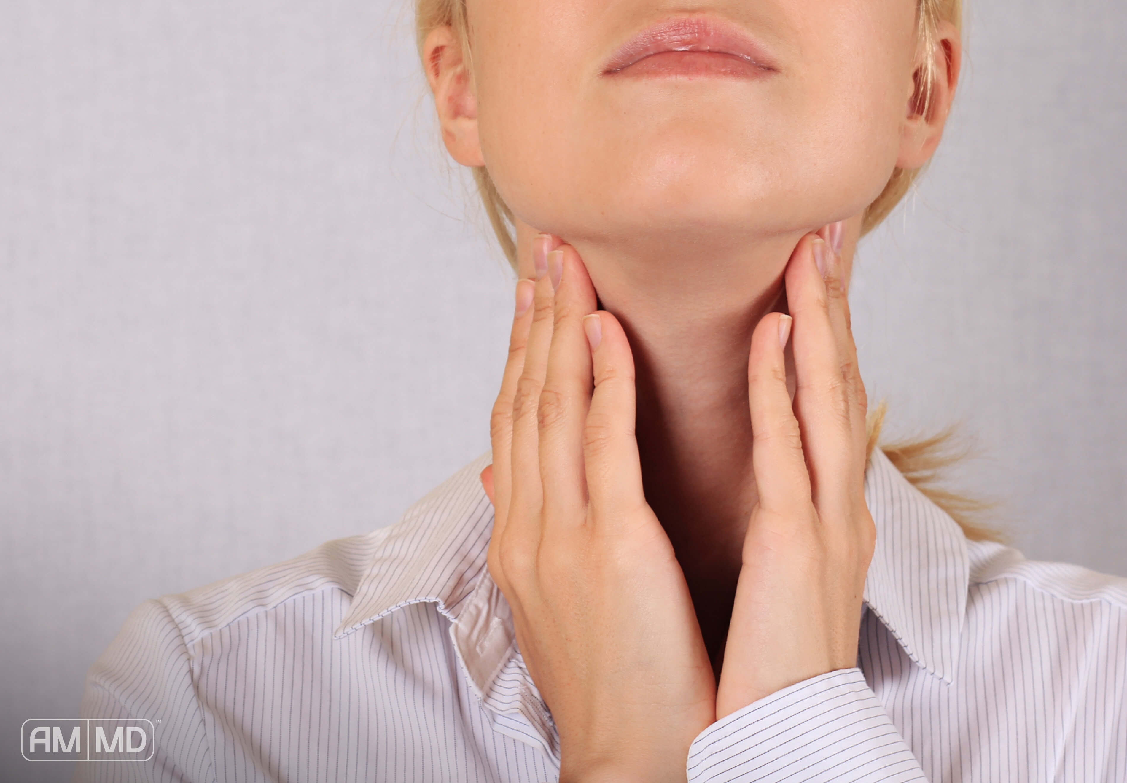 Woman feeling for thyroid in neck - Thyroid Health - 4 Essential Nutrients - Amy Myers MD®
