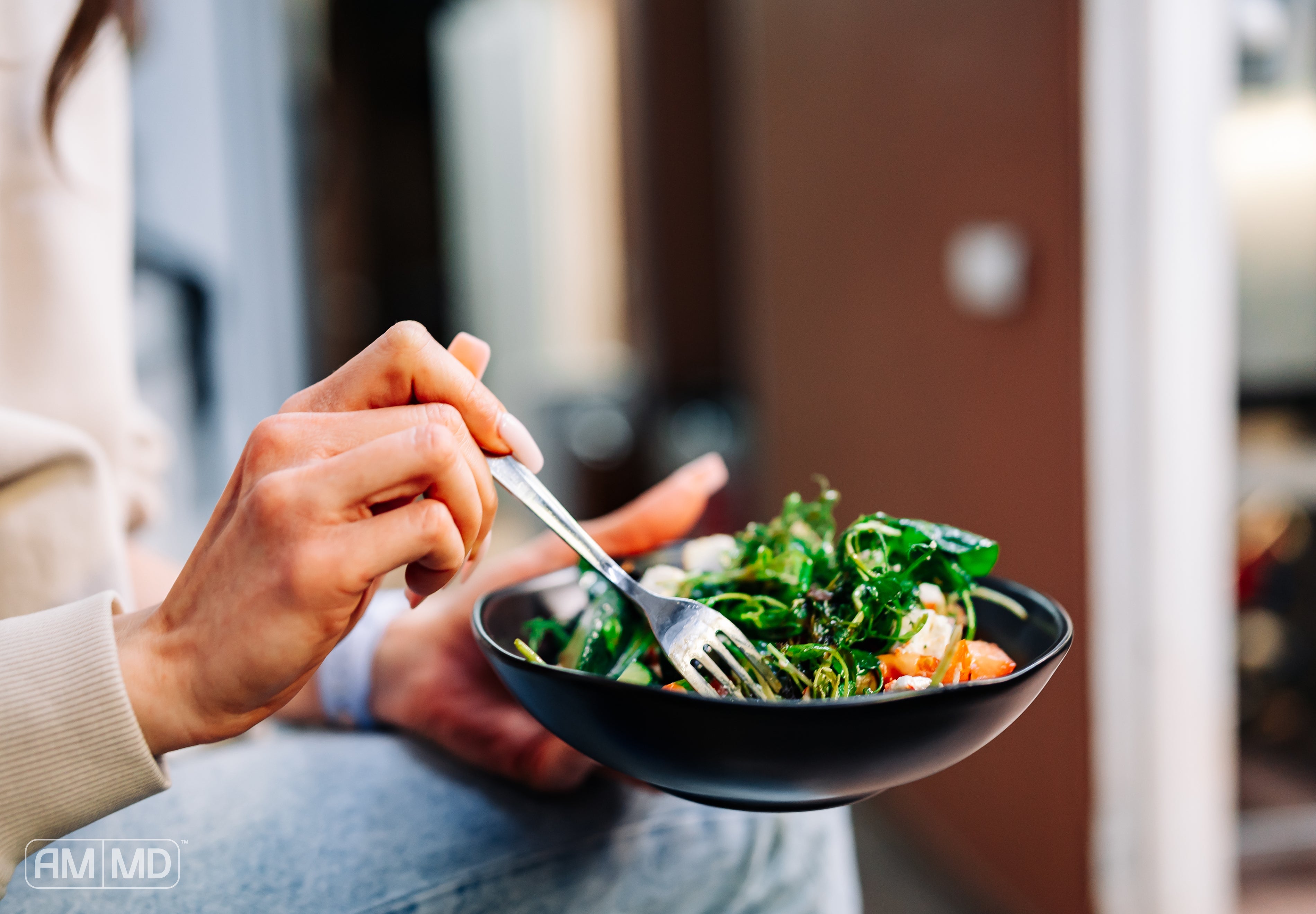 Woman eating a salad bowl - 8 High-Energy Foods to Support Your Daily Routine - AMMD™