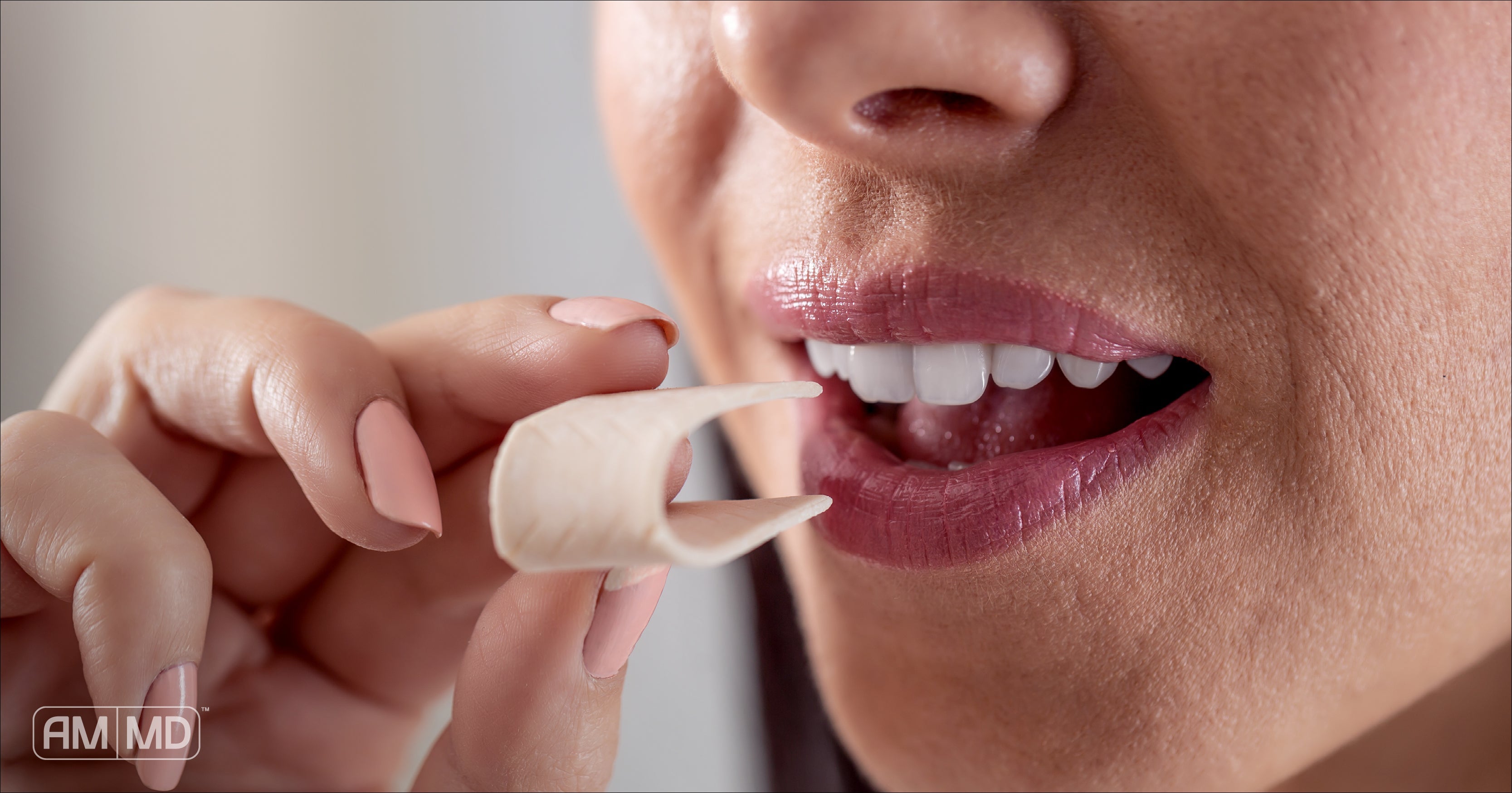 Woman putting a piece of gum in her mouth - Are Sugar Alcohols Bad For You? - AMMD™