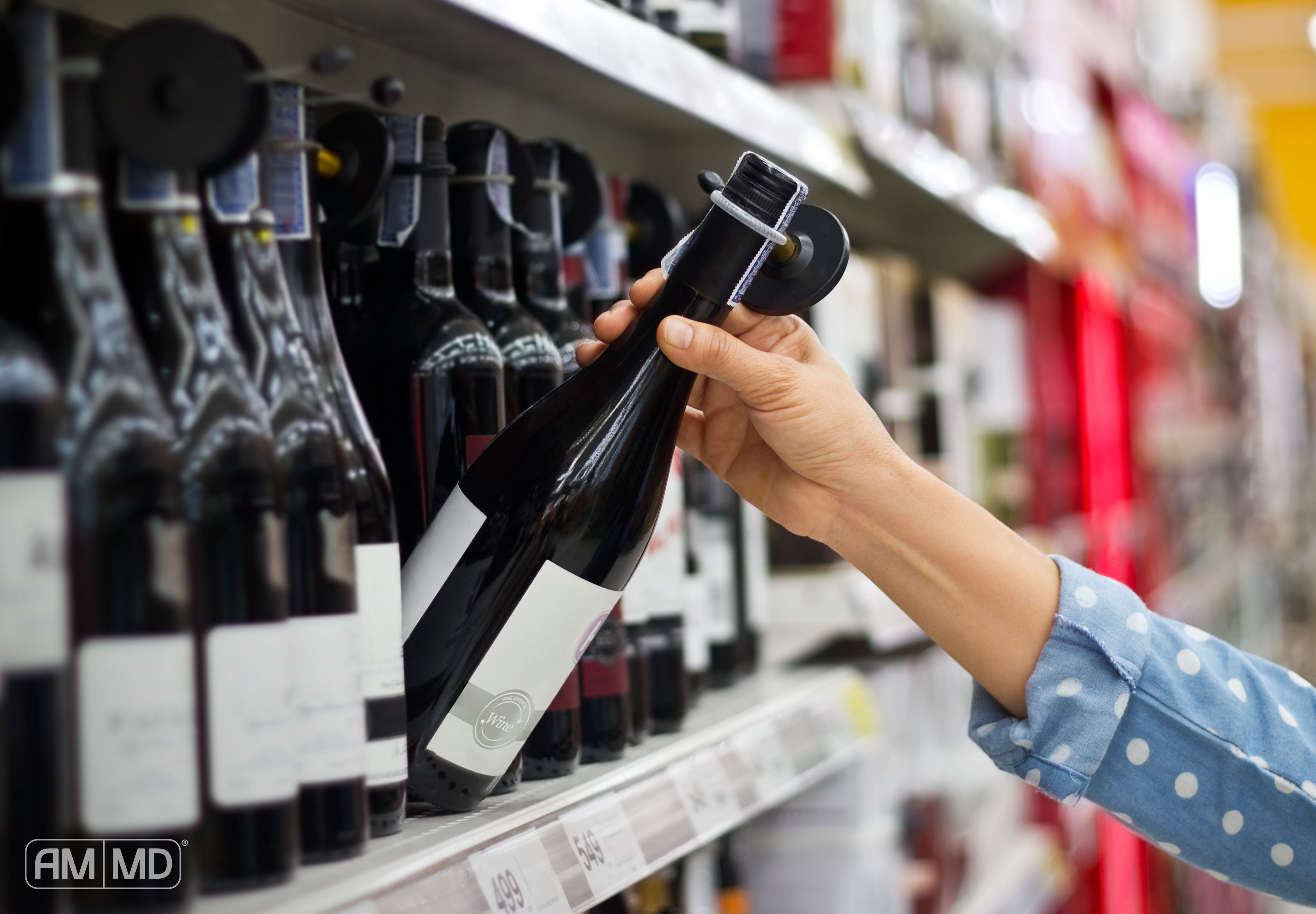 Grabbing a wine bottle off the store shelf - Being Sober Curious is More Than Just a Trend - AMMD™