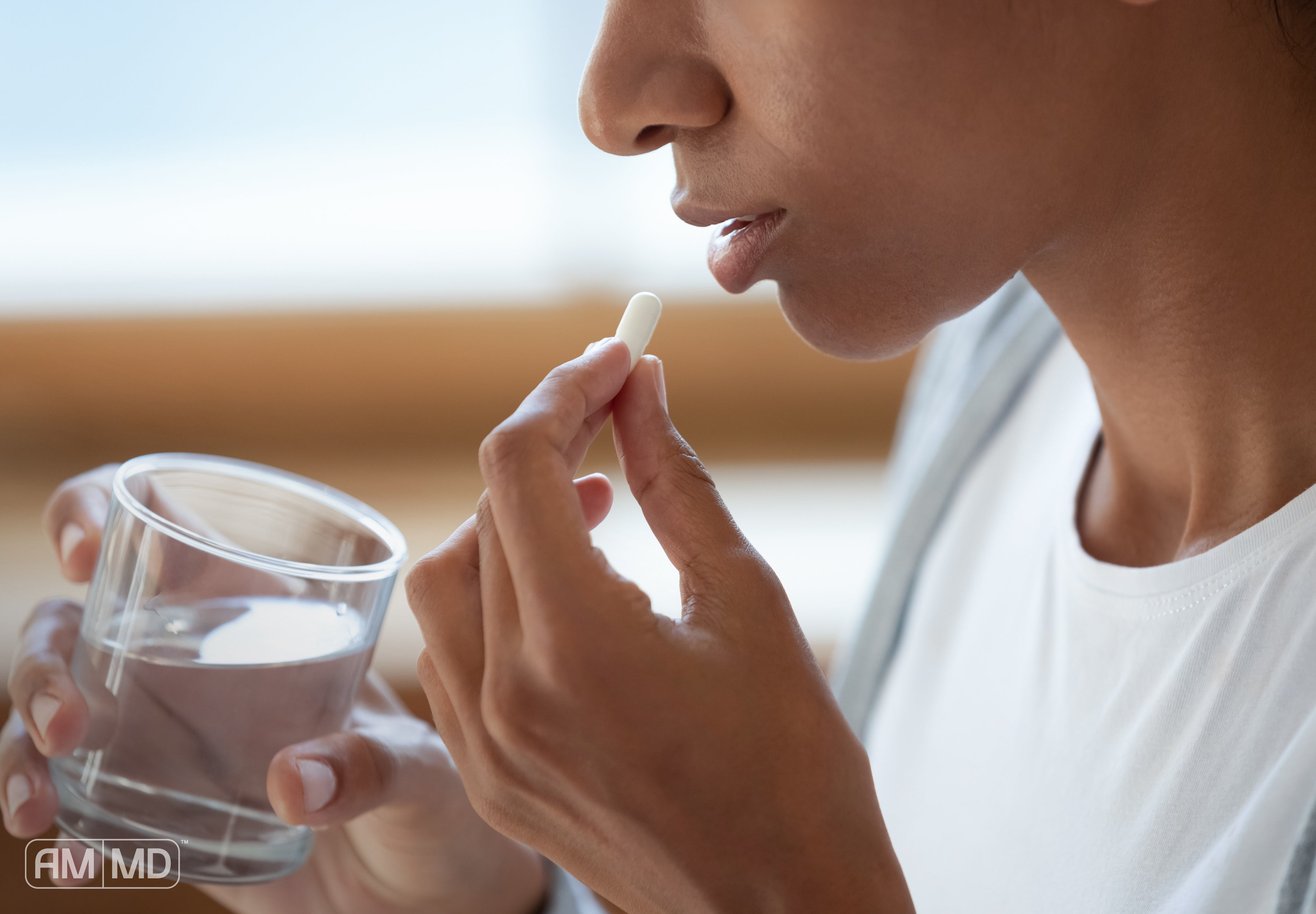 Woman taking probiotic - Can Probiotics Help or Cause SIBO? - AMMD™