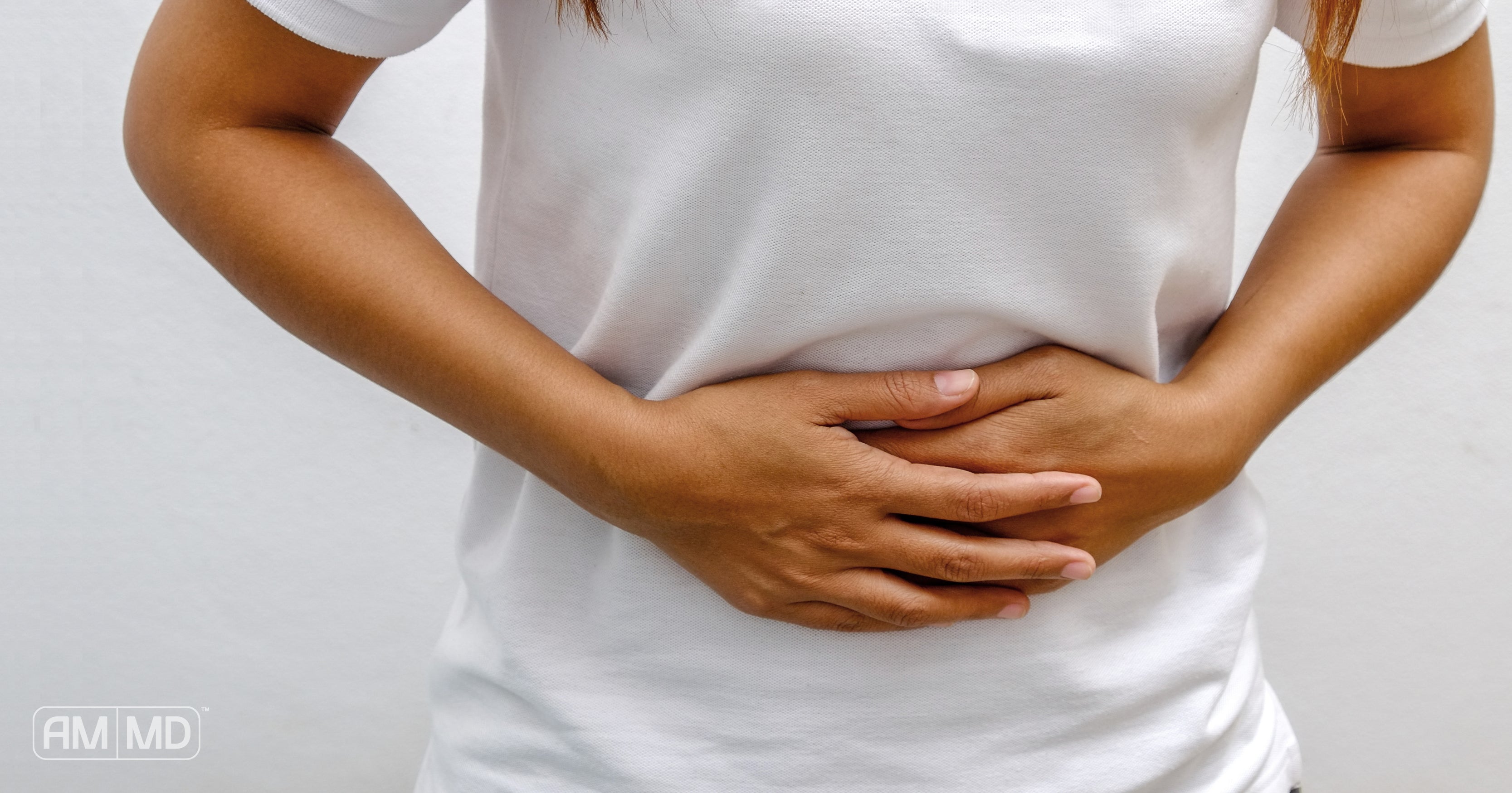 Woman holding stomach - Gluten, Leaky Gut, Gluten Intolerance, and Celiac Disease - AMMD™