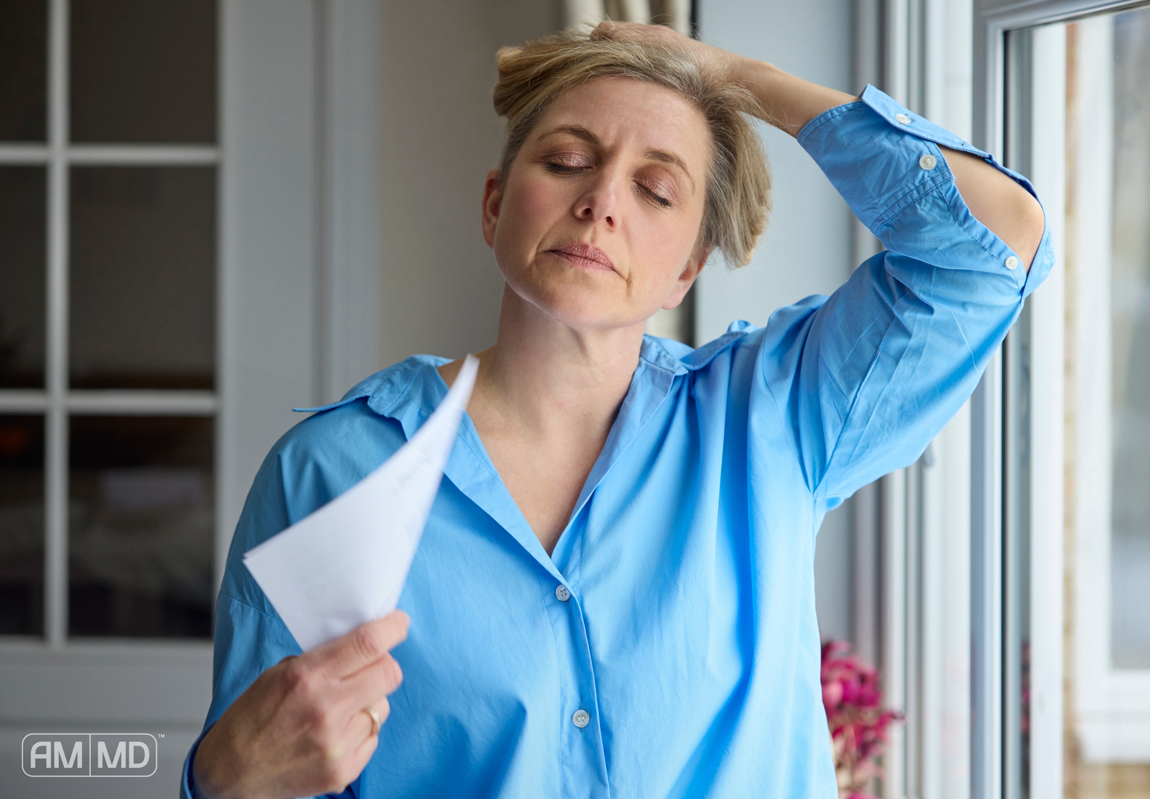 Woman fanning herself - How To Manage Perimenopause with Targeted Support - AMMD™