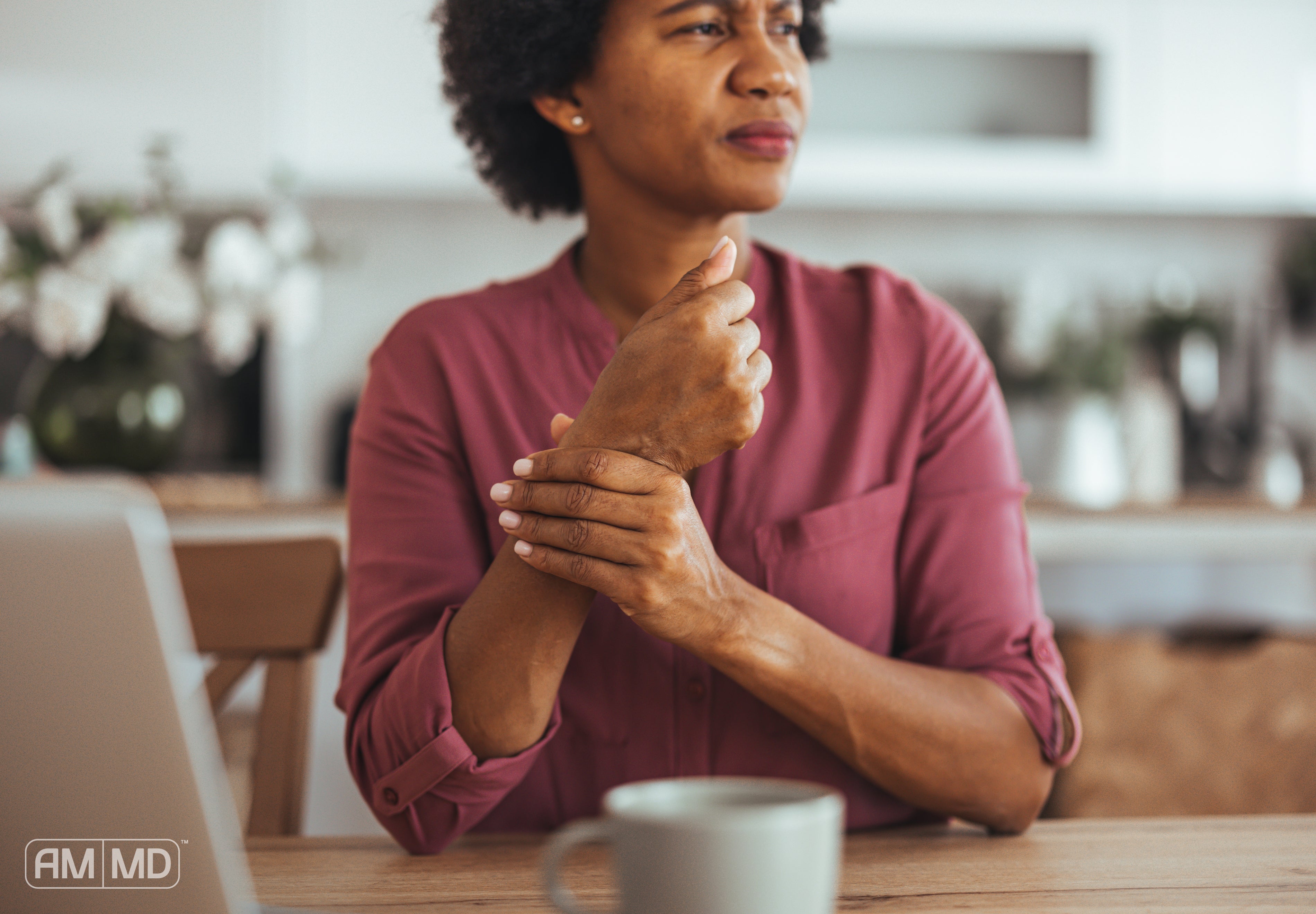 Woman holding wrist in pain - How to Reduce Inflammation in the Body Naturally - AMMD™