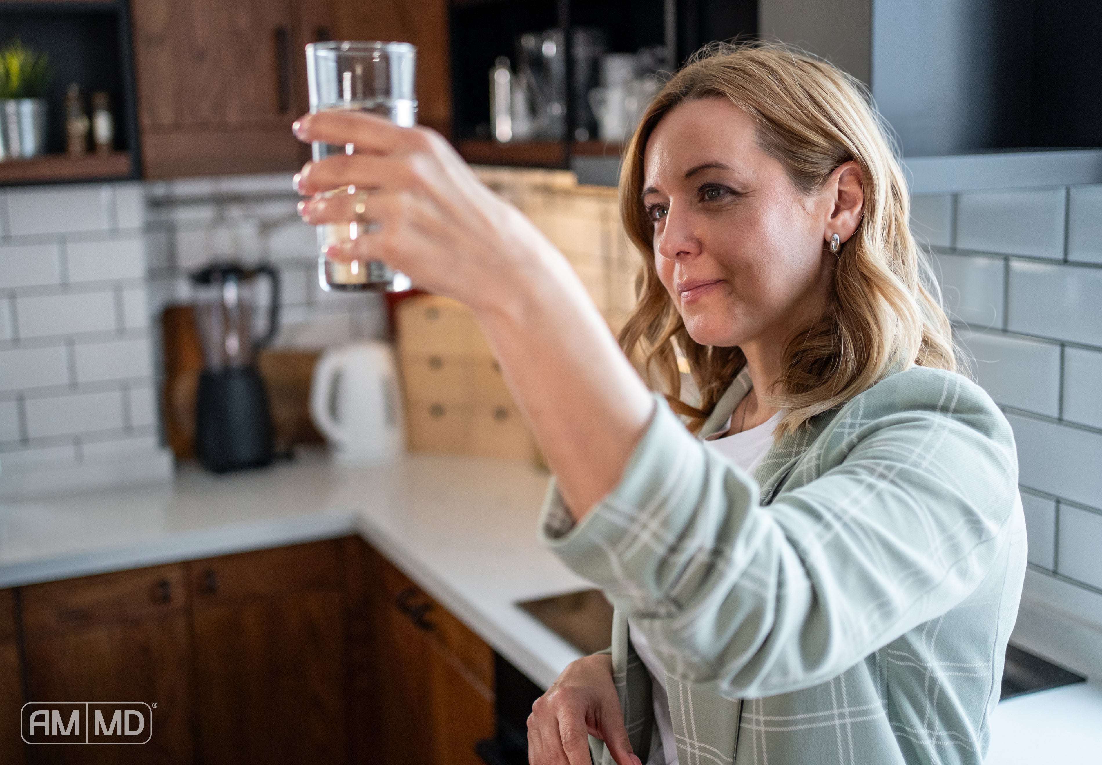 Woman checking glass of water - How To Test For Toxins - AMMD™
