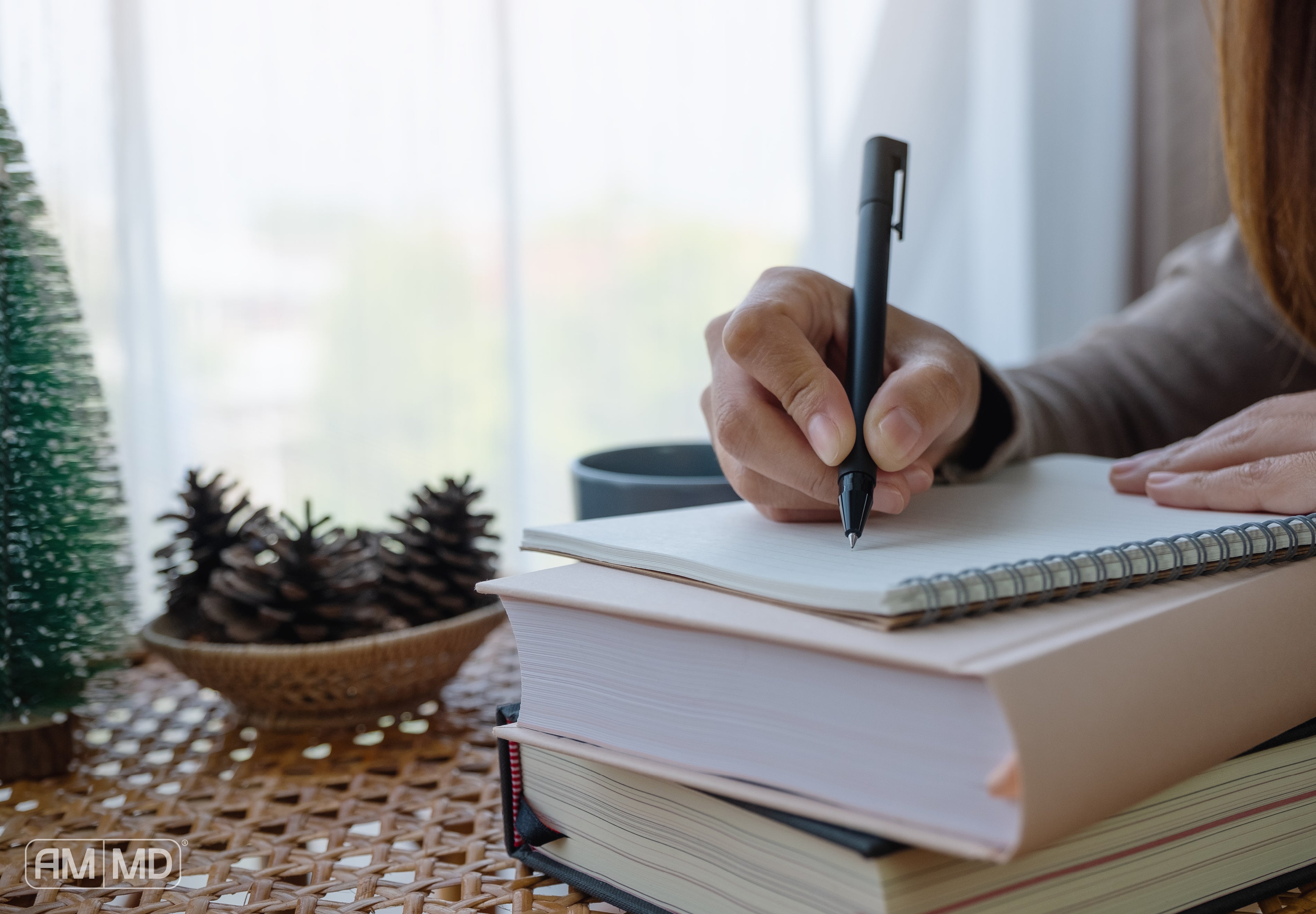 Woman writing in a notepad - New Year's Health Resolutions Made Easy With AMMD™ Protocols - AMMD™