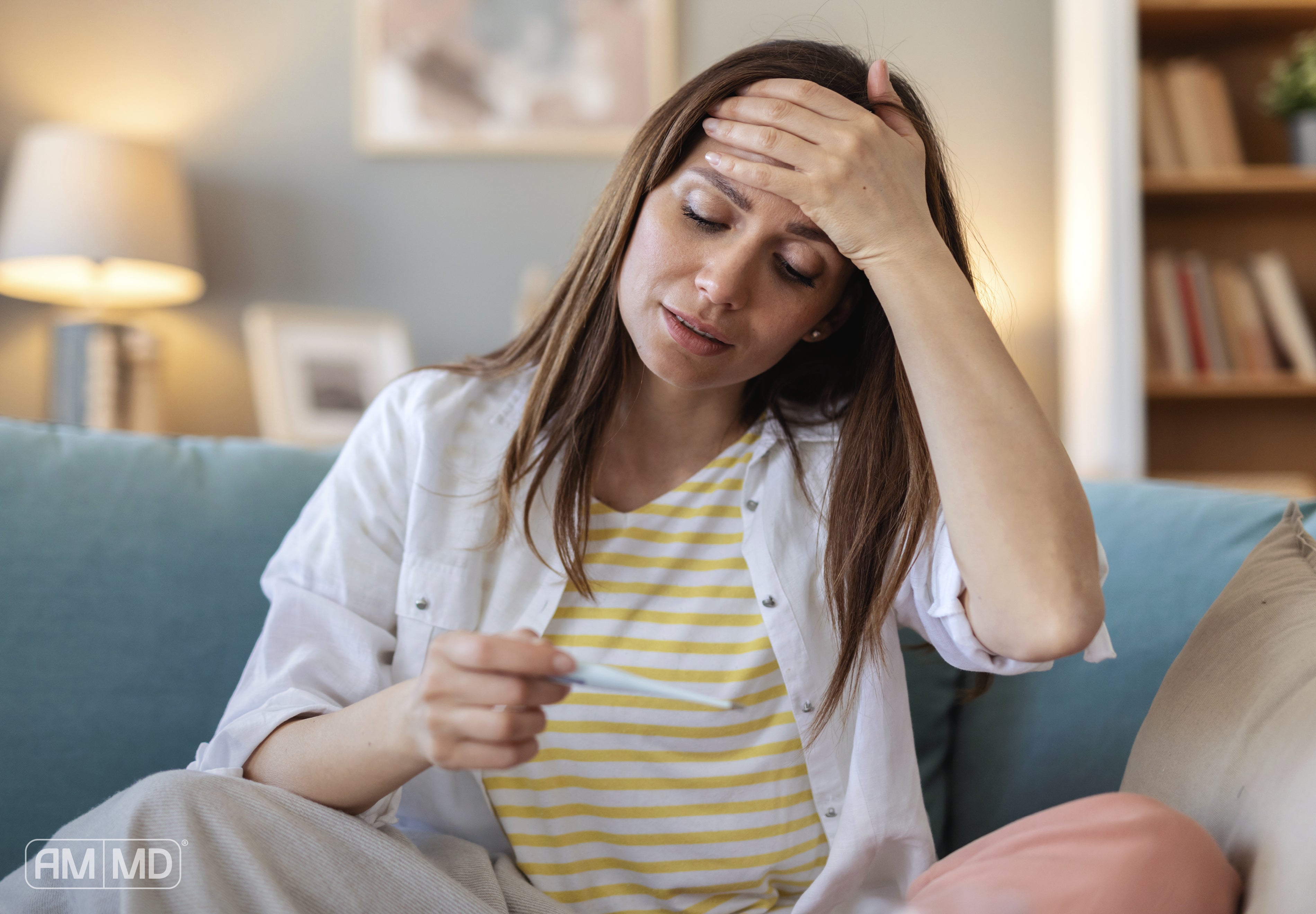 Woman looking fatigued while checking a thermometer, representing symptoms of EBV and immune system dysfunction