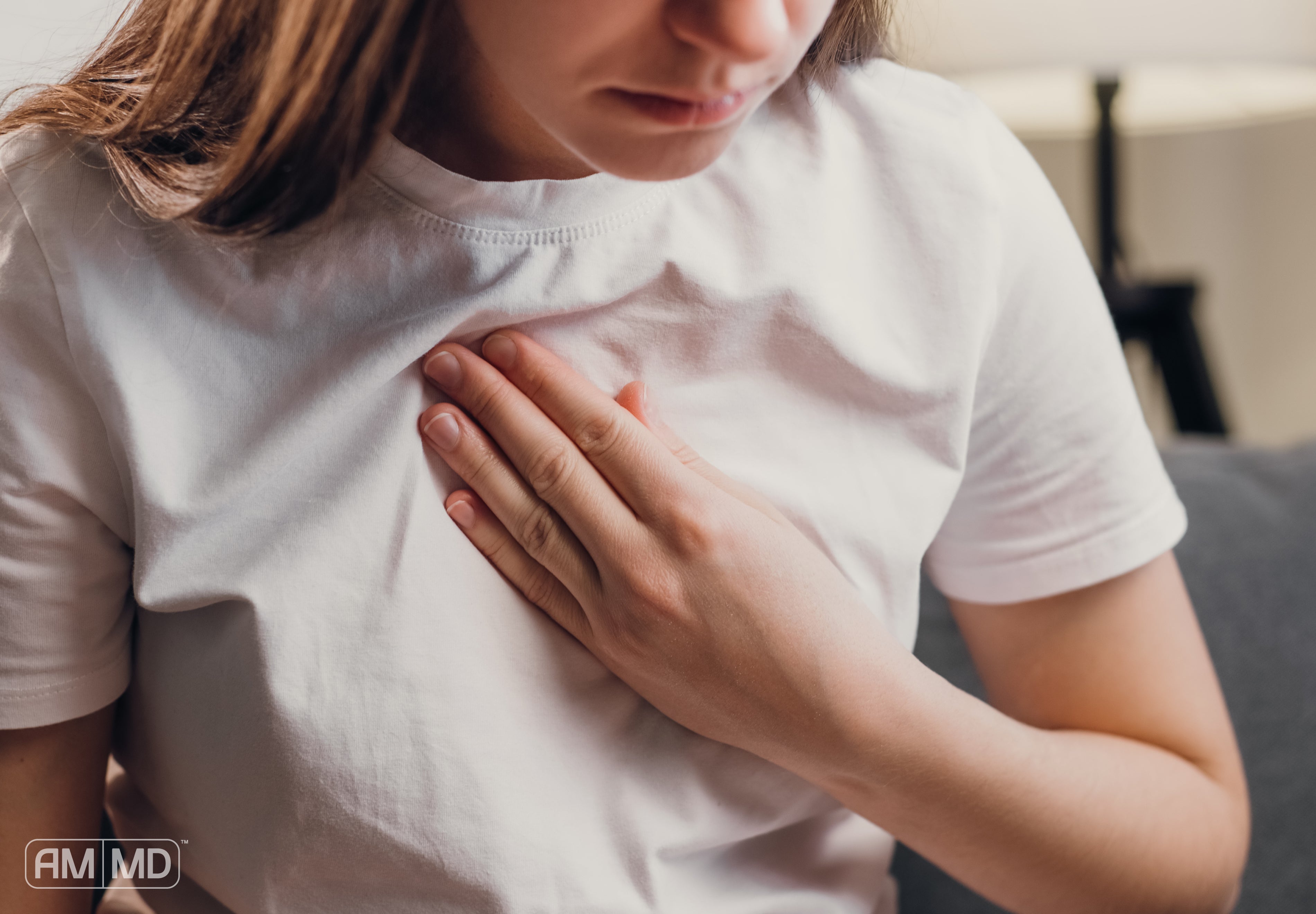 Woman holding chest - Understanding Bile Reflux: Causes, Symptoms, and Solutions - AMMD™