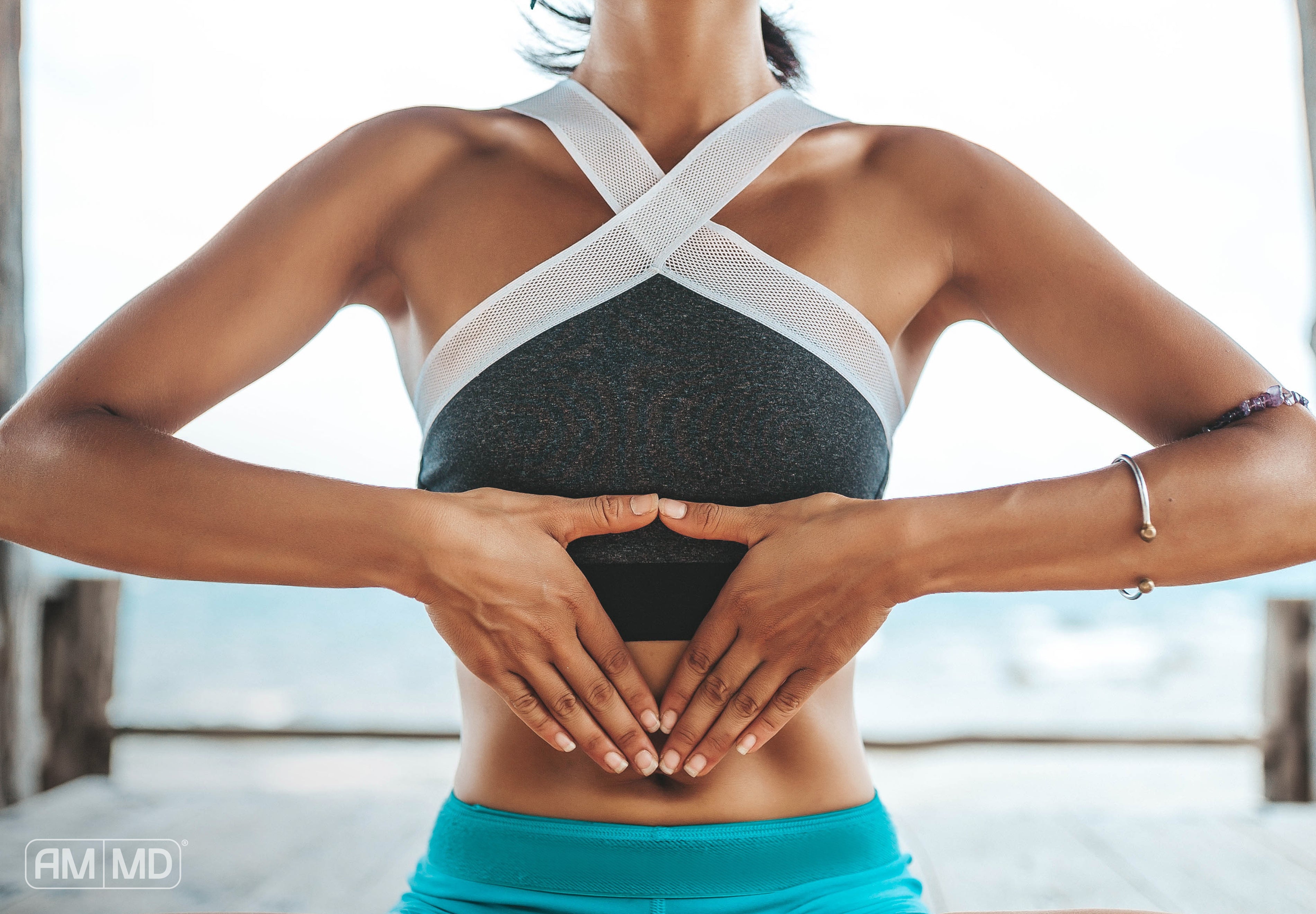 Woman making triangle around belly - Vagal Tone: The Gut-Brain Axis & the Vagus Nerve - AMMD™