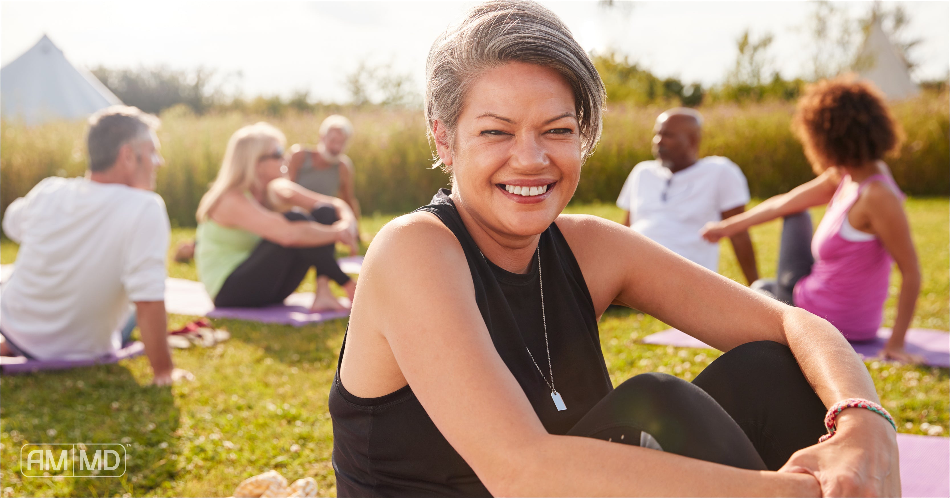 Woman sitting on a yoga mat smiling - Why L-Glutamine is the #1 Ingredient for Repairing Leaky Gut - AMMD™