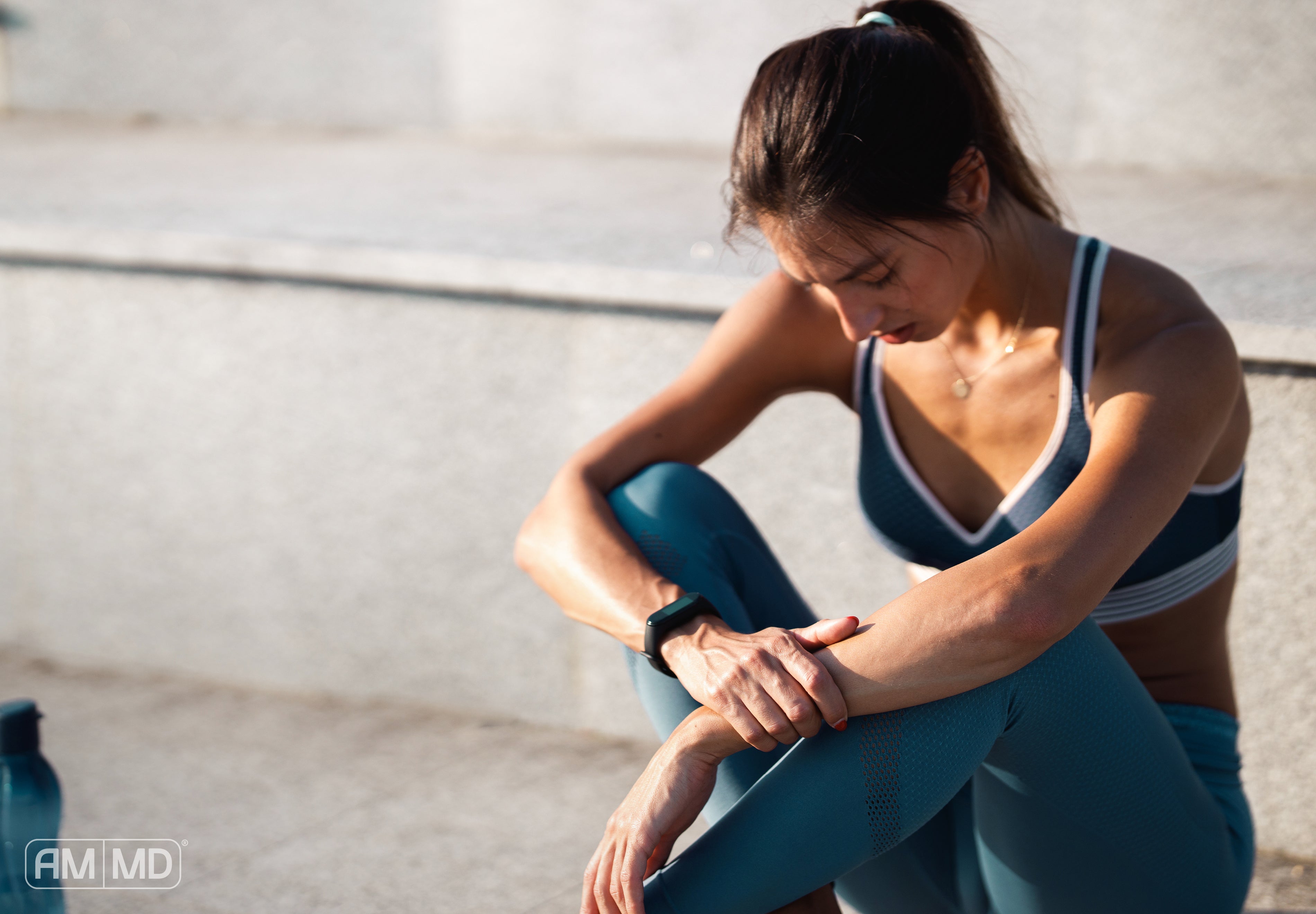 Woman in workout clothes sitting in the sun - Why Most New Year Health Goals Fail (And What Actually Works) - AMMD™