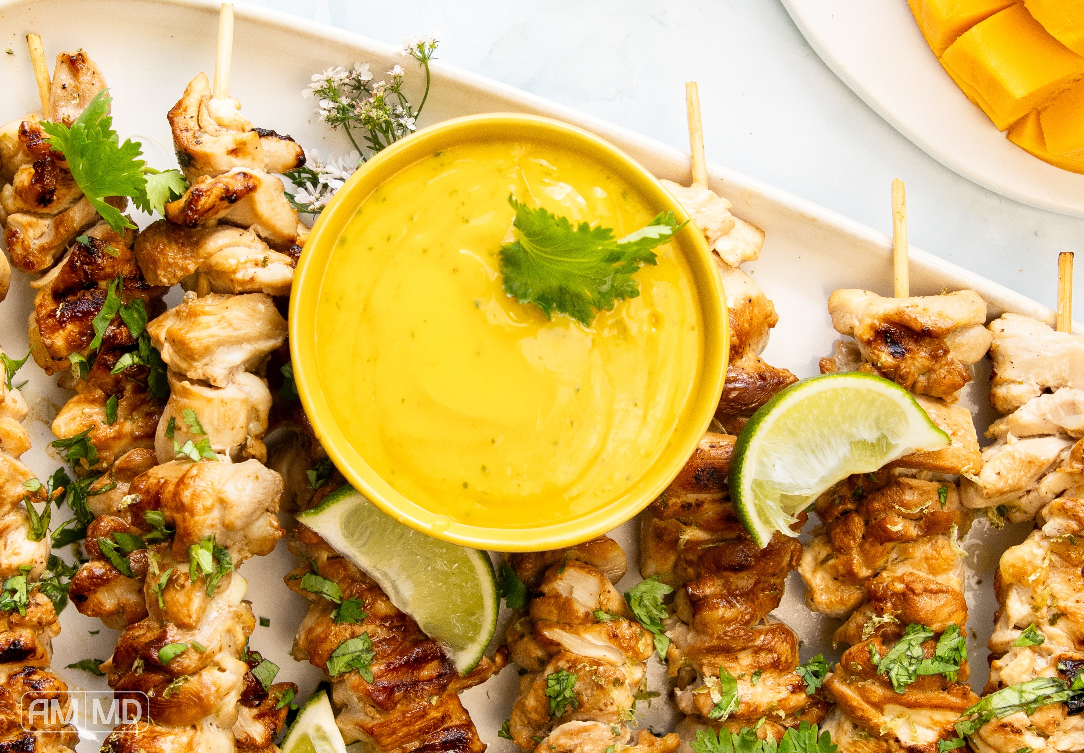 AIP Thai chicken skewers with mango curcumin sauce and lime wedges