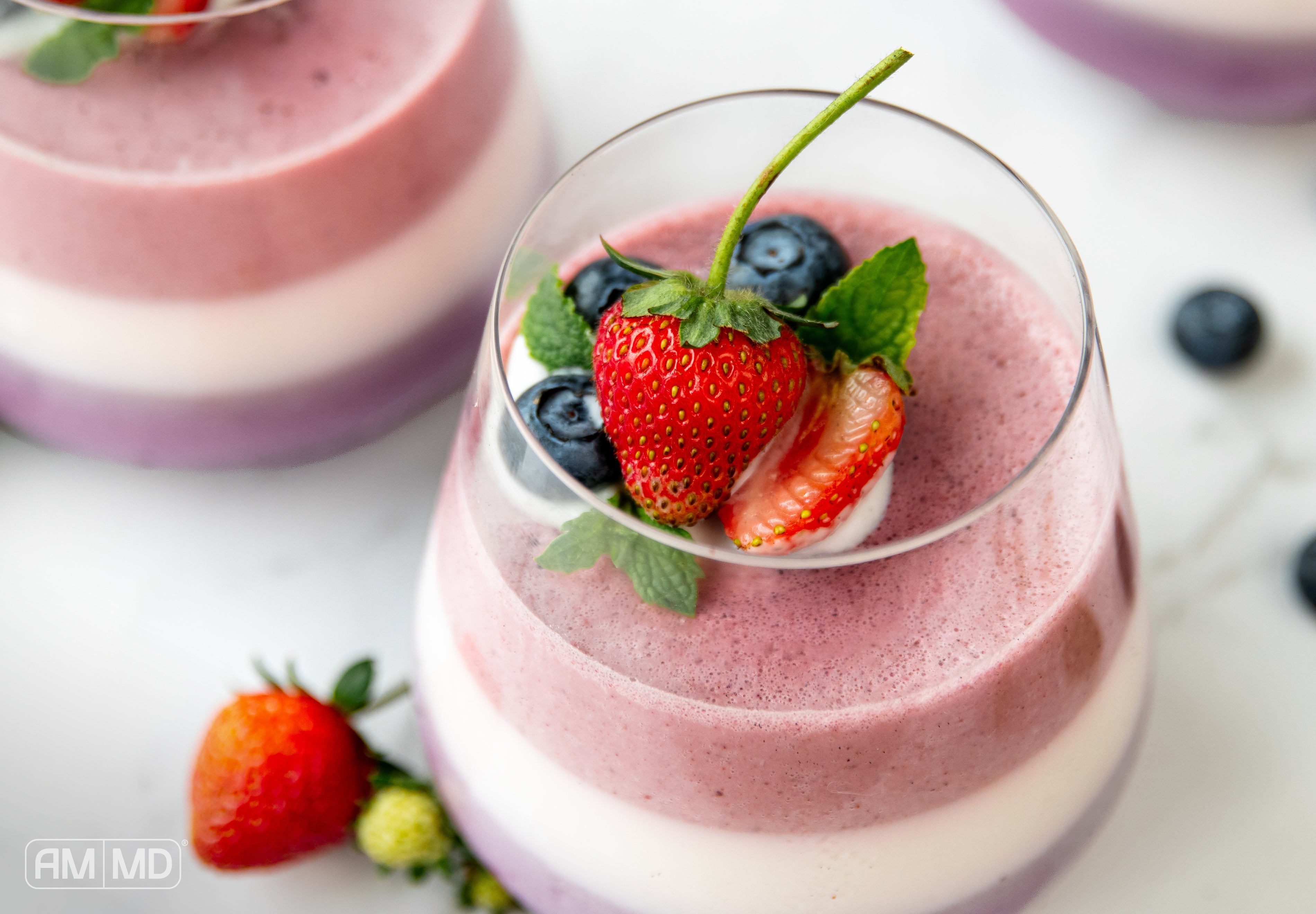 Dairy-free triple layer panna cotta topped with fresh strawberries, blueberries, and mint for a healthy patriotic dessert